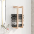 Wall-mounted pine towel rack holding rolled towels in a bathroom