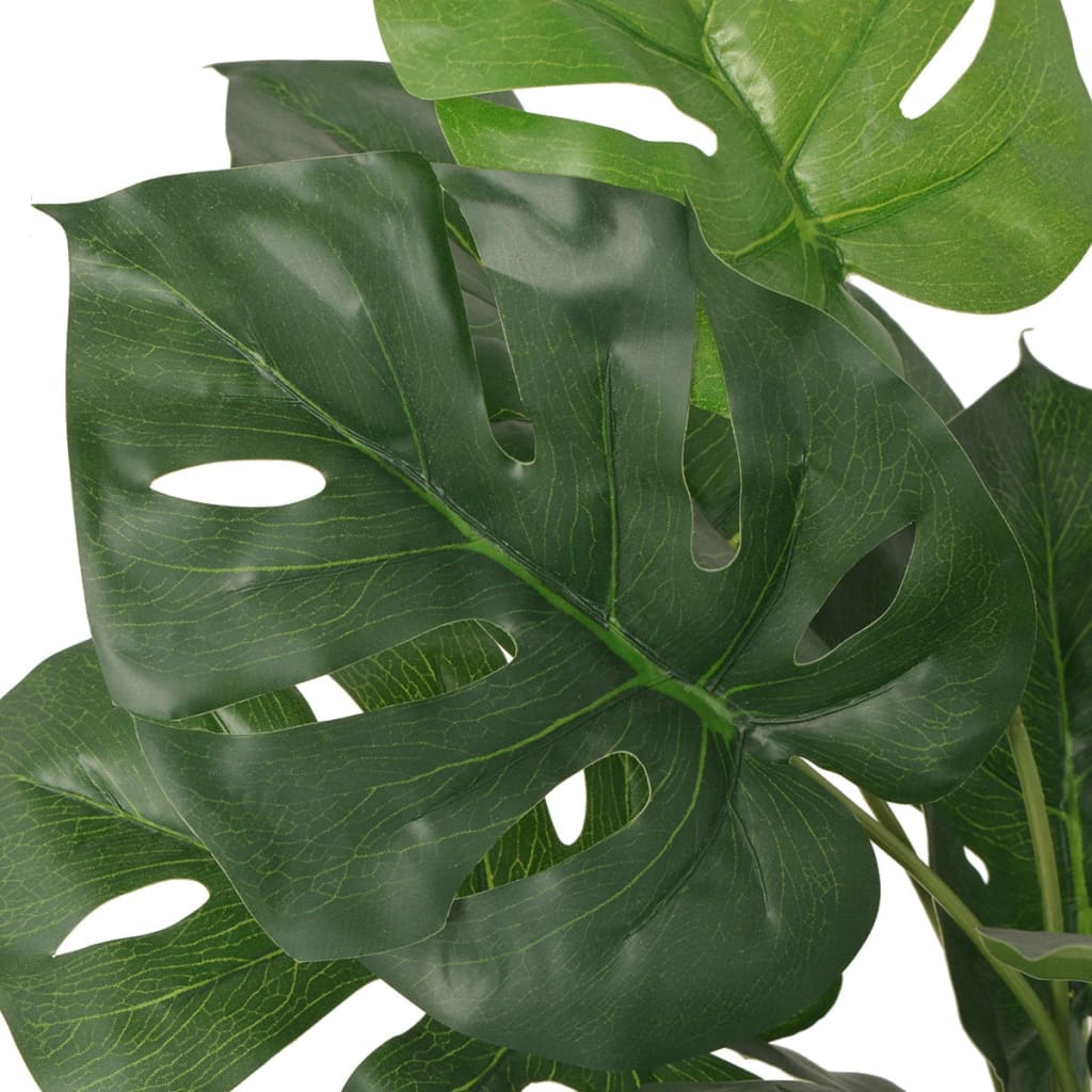 Artificial monstera plant shown in room setting